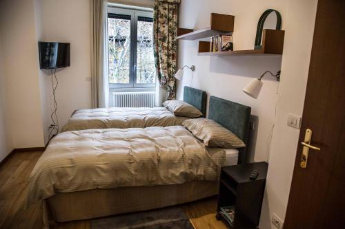 ローマにあるCasa con Terrazzino Trastevereの窓付きの小さな部屋のベッド2台