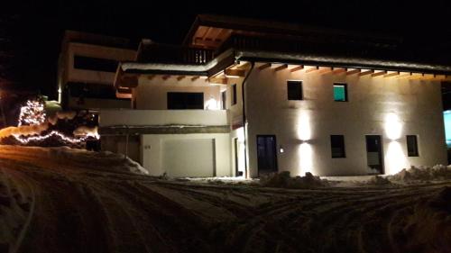 a building in the snow at night at Ferienwohnung Heissl in Fieberbrunn