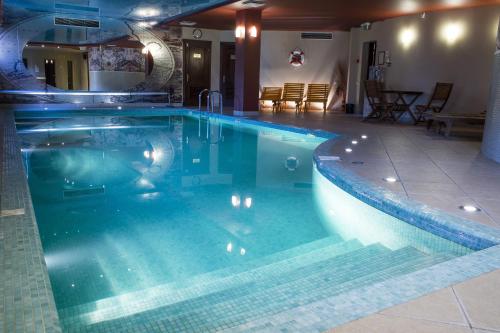 a large swimming pool in a room with a table at Port Hotel in Ādaži