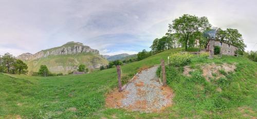 an old house on a grassy hill with a path at Cabañas con Encanto in San Roque de Ríomiera