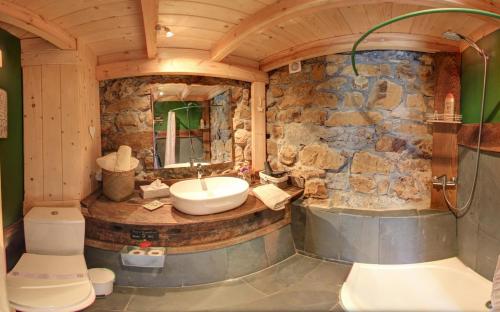 a bathroom with a sink and a stone wall at Cabañas con Encanto in San Roque de Ríomiera
