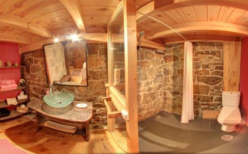 a bathroom with a sink and a stone wall at Cabañas con Encanto in San Roque de Ríomiera