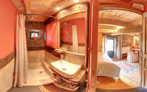 a bathroom with a sink and a bed and a mirror at Cabañas con Encanto in San Roque de Ríomiera