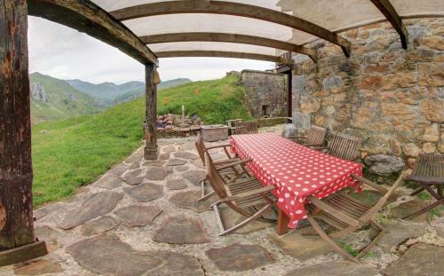 a table and chairs on a patio with a mountain at Cabañas con Encanto in San Roque de Ríomiera