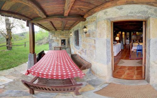 eine Terrasse mit einem Tisch und Bänken auf einem Gebäude in der Unterkunft Cabañas con Encanto in San Roque de Ríomiera