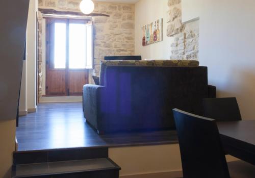 a living room with a blue couch and a window at Apartamentos Sol de Mayo in Úbeda