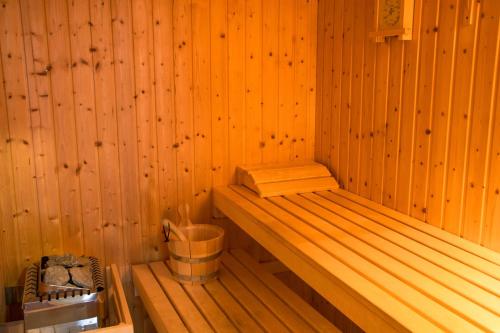 a sauna with a bench and a bucket in it at Saint Catherine Hotel in Pythagoreio