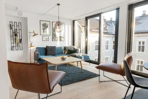 een woonkamer met een blauwe bank en een tafel bij Frogner House - Grünerløkka in Oslo