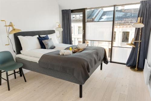 1 dormitorio con cama y ventana grande en Frogner House - Grünerløkka en Oslo