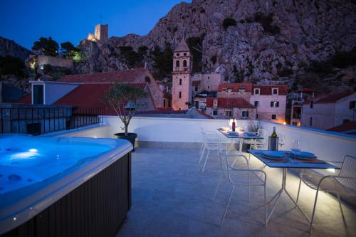 a swimming pool with tables and chairs on a roof at Stone House Franco in Omiš