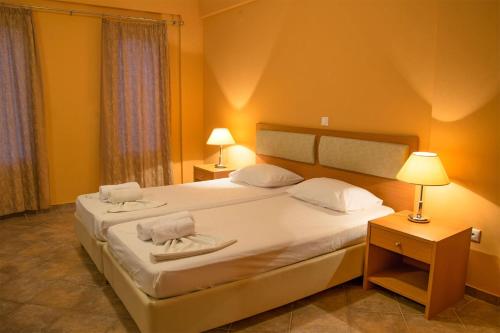 a bedroom with a large bed with two towels on it at Saint Catherine Hotel in Pythagoreio