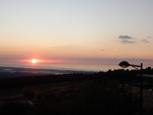 a sunset from the top of a hill with a street light at הים פוגש את ההר- בית בלב הגליל Sea & Mount in Adamit