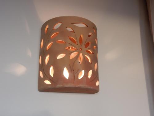 a brown light fixture on a white wall at הים פוגש את ההר- בית בלב הגליל Sea & Mount in Adamit