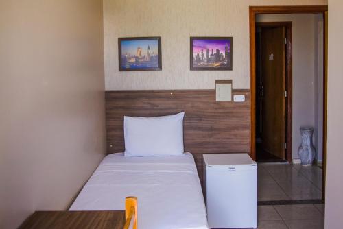 a bedroom with a bed with a wooden headboard at Barbara's Hotel in Junqueirópolis