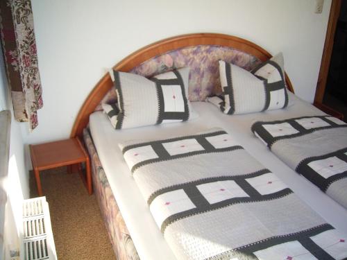 a bed with black and white pillows on it at Haus Panorama in Lermoos