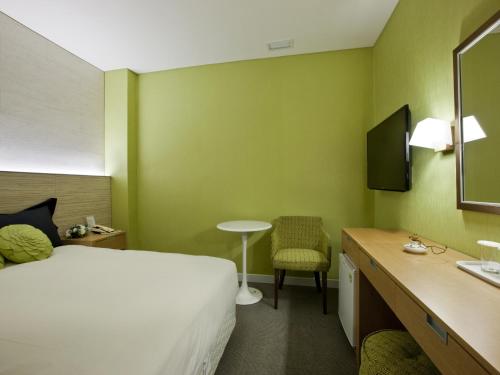 a hotel room with a bed and a desk and a chair at Central Tourist Hotel in Seoul