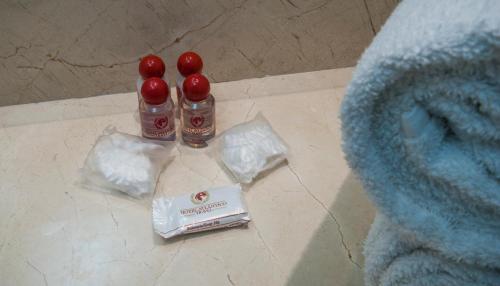two bottles of tooth paste sitting on a floor next to a bed at Hotel Atlântico Travel Copacabana in Rio de Janeiro
