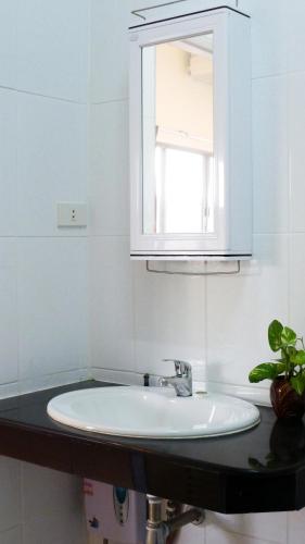 a white sink in a bathroom with a mirror at Metro Apartments in Pattaya