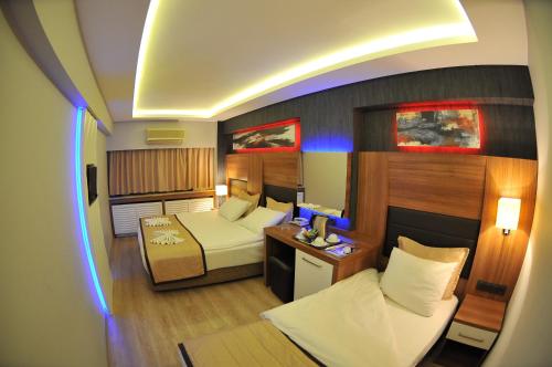 a room with a bedroom with a bed and a desk at İzmir Otel Kabaçam in İzmir