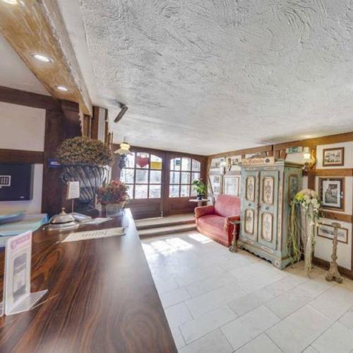 a large living room with a red couch and tables at Hotel Peter Schaefer in Ginsheim-Gustavsburg