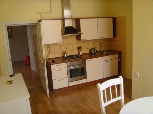 Il comprend une petite cuisine avec des placards blancs et une cuisinière. dans l'établissement Vilhelm's Apartment, à Klaipėda