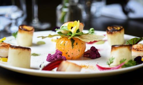 a white plate with food on a table at Mercure Dijon Centre Clemenceau in Dijon