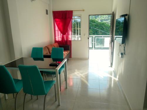 sala de estar con mesa y sillas verdes en Apartamento en Taganga en Taganga