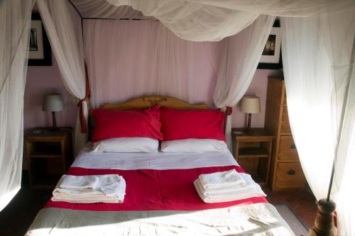 La Balconata في باني دي لوكا: غرفة نوم بسرير ومخدات حمراء