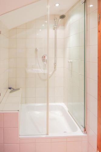 a bathroom with a shower and a bath tub at Apartments- und Ferienhaus Anton in Garmisch-Partenkirchen