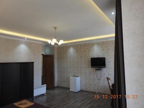 a living room with a flat screen tv on the wall at White Hotel Guesthouse in Zugdidi