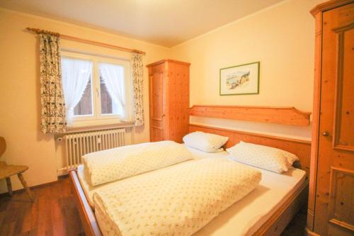 1 dormitorio con 2 camas y ventana en Apartments- und Ferienhaus Anton, en Garmisch-Partenkirchen