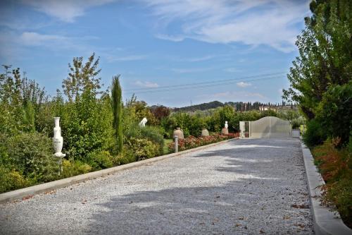 a road in a garden with trees and bushes at Cevoli Country Resort in Lari