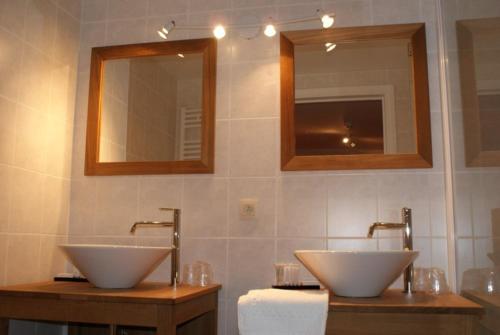 a bathroom with two sinks and two mirrors at Auberge Le Temps des Saveurs in Paliseul