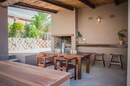a patio with a table and chairs and a fireplace at Aan de Heuvel Self-Catering Cottages in Swellendam