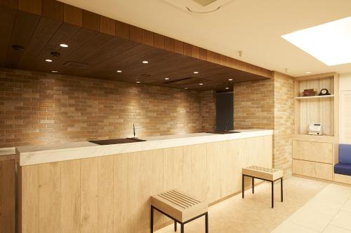 a lobby with a bar with two stools at Sotetsu Fresa Inn Ginza Sanchome in Tokyo