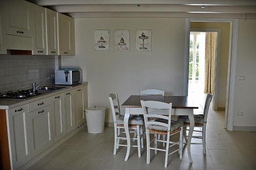 a kitchen with a table and chairs and a microwave at Cevoli Country Resort in Lari