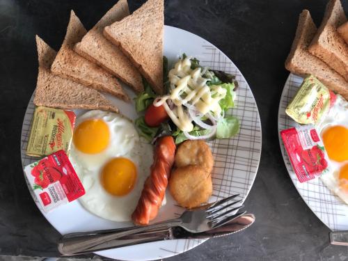 un piatto di prodotti per la colazione con uova e pane tostato di La Chambre Boutique @ Ko Lanta a Ko Lanta