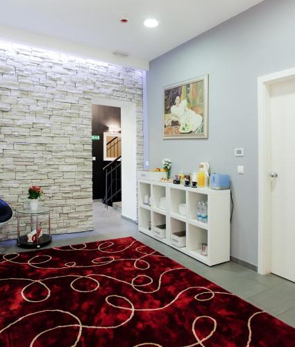 a living room with a red rug and a brick wall at Hotellux B&B in Zagreb