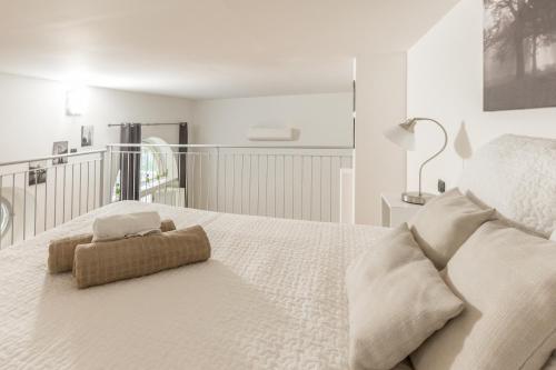 a white bedroom with a large white bed with a chair at Alessia's Flat- Portello 2 in Milan