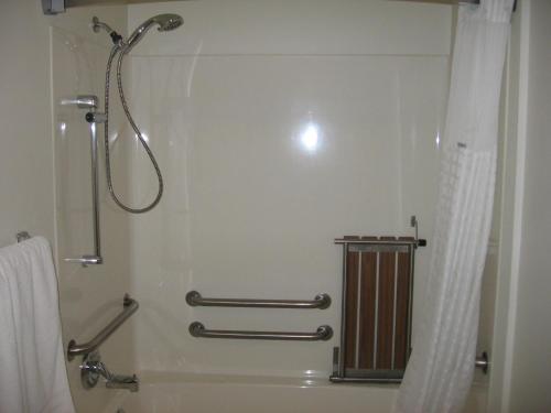 een douchecabine in een badkamer met een douchegordijn bij AmericInn by Wyndham Mauston in Mauston
