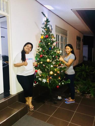 two women standing next to a christmas tree at White Villa Airport Transit Hotel in Katunayake