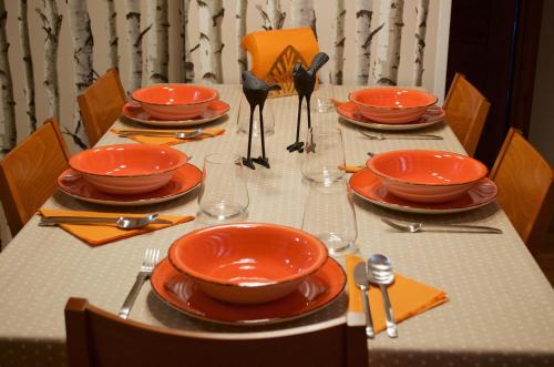 a table with orange plates and utensils on it at Les Ares in Esterri d'Àneu