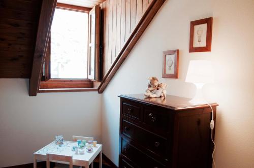 a doll sitting on top of a dresser in a room with a window at Les Ares in Esterri d'Àneu