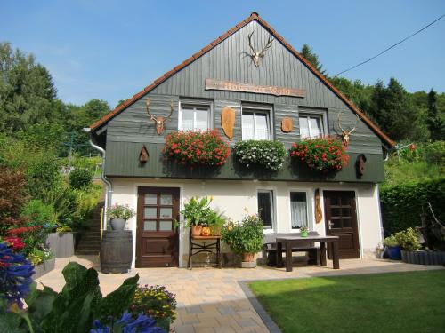 a house with flowers and plants in front of it at Ferienhaus Haus am Wald in Stolberg i. Harz