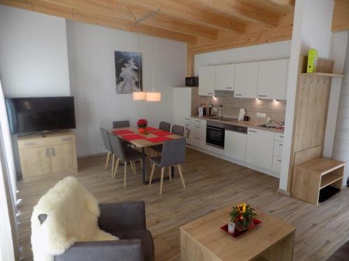 a kitchen and living room with a table and chairs at Naturparkferienwohnungen Wolf in Hofen