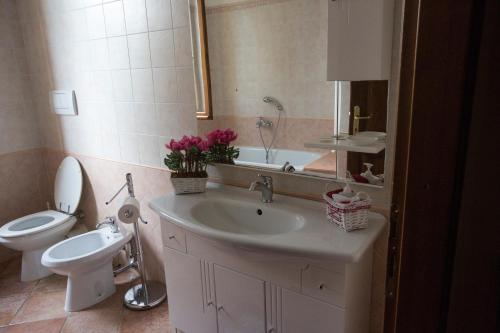 a bathroom with a sink and a toilet and a mirror at La Maestà Tuscan Sun in Cortona