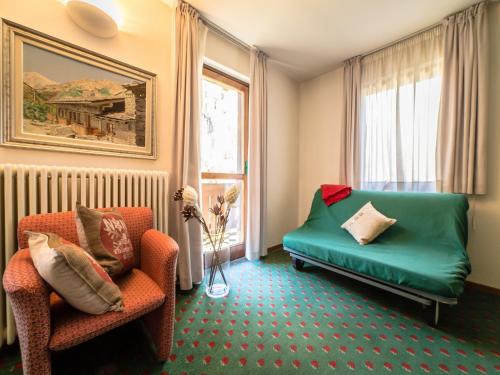 a living room with a green couch and a chair at Residence Apfel in Gressoney-Saint-Jean