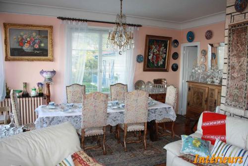 a dining room with a table and chairs and a room with at Villa Erresiñolettean in Ciboure