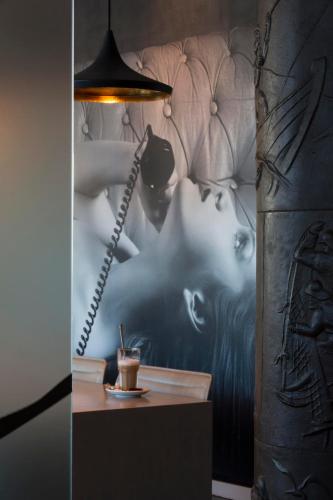 a room with a table with a drink and a lamp at Comfort Hotel Eskilstuna in Eskilstuna