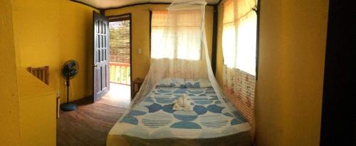 a bed in a room with a window at Guanna's Place Room and Resto Bar in Malapascua Island